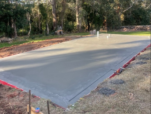 Freshly poured slab inside timber formwork on a rural site