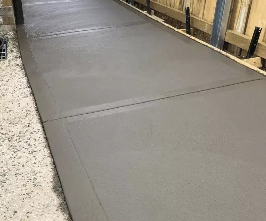Concrete path running down the side of a house with cut joints