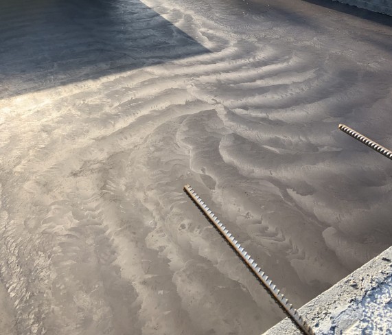 Fresh concrete being floated during a pour
